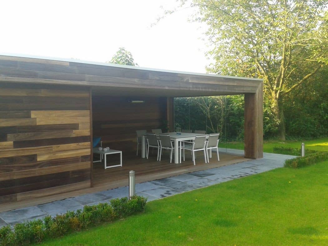 Houten overkapping met eethoek, verlicht pad en gazon