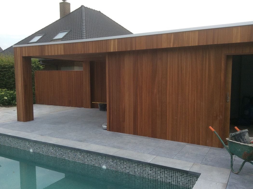 Poolhouse in warm hout naast een zwembad met mozaïekrand